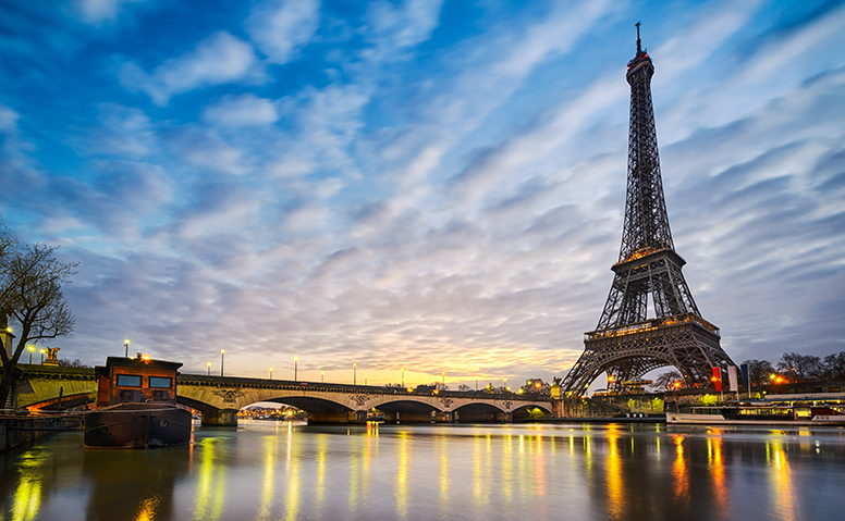 France: shot of the illuminated Eiffel Tower at dusk, the lights reflected on water in the foreground France: shot of the illuminated Eiffel Tower at dusk, the lights reflected on water in the foreground